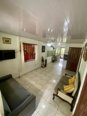 a living room with a couch and a tv at La Casa de Tita in Orotina