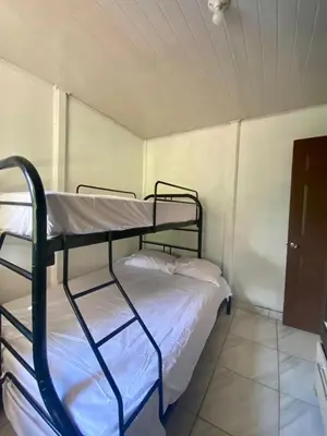 a bedroom with two bunk beds in a room at La Casa de Tita in Orotina