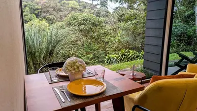 a wooden table with a plate of food on it at Olingo Monteverde - Studio Apartment with Jacuzzi in Monteverde Costa Rica