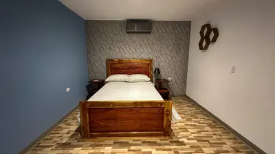 a bedroom with a wooden bed and blue walls at Olas del alba in Tapantí