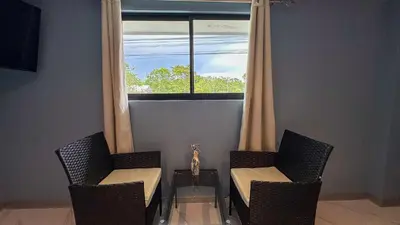 two chairs and a table in front of a window at Olas del alba in Tapantí