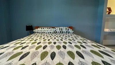 a bedroom with a bed with a quilt on it at Olas del alba in Tapantí