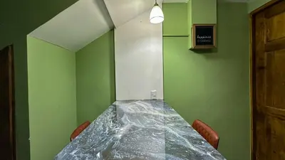 a long table in a room with green walls at Olas del alba in Tapantí