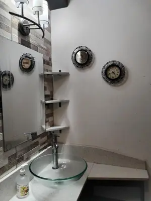 a bathroom with a sink with a mirror and plates on the wall at Casa en San José de la Montaña in Heredia