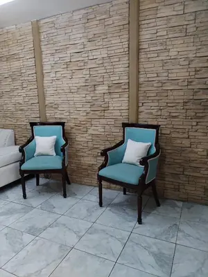 two chairs with pillows sitting next to a brick wall at Casa en San José de la Montaña in Heredia