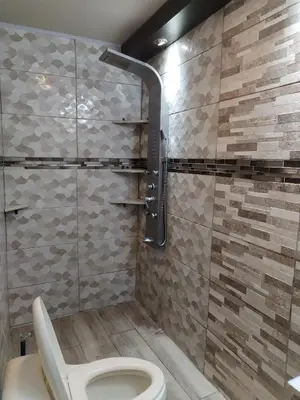 a bathroom with a toilet and a glass shower at Casa en San José de la Montaña in Heredia