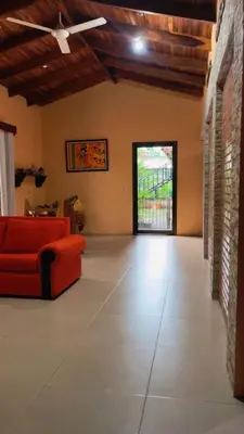 a living room with a red couch and a window at Green Shelter in Quepos