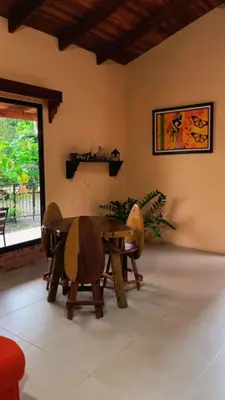 a dining room with a wooden table and chairs at Green Shelter in Quepos