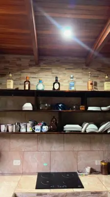 a shelf in a kitchen with many items on it at Green Shelter in Quepos