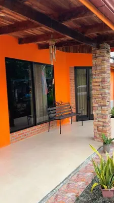 a bench sitting on the front porch of a house at Green Shelter in Quepos