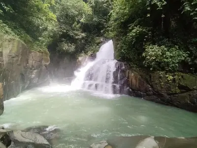 a waterfall in the middle of a pool of water at La Ceiba Ecoadventures Wildlife Reserve in Platanillo