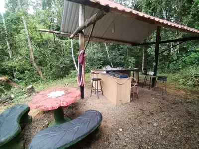 a tent with a table and an umbrella at La Ceiba Ecoadventures Wildlife Reserve in Platanillo