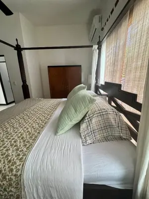 a bedroom with a bed with pillows and a window at Beachfront Paradise in Tivives, Costa Rica - Your Home Away from Home in Tivives
