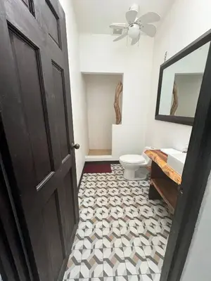 a bathroom with a black door and a toilet and a sink at Beachfront Paradise in Tivives, Costa Rica - Your Home Away from Home in Tivives