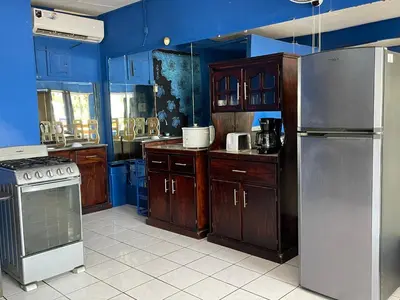 a kitchen with wooden cabinets and stainless steel appliances at Beach Studio for 4 - AC - WiFi - Parking Santa Teresa in Santa Teresa