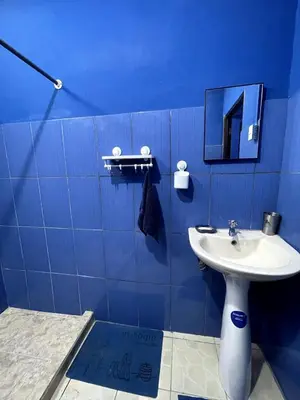a blue bathroom with a sink and a mirror at Beach Studio for 4 - AC - WiFi - Parking Santa Teresa in Santa Teresa