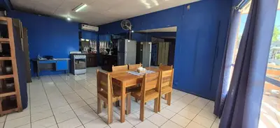 a kitchen with a wooden table and a blue wall at Beach Studio for 4 - AC - WiFi - Parking Santa Teresa in Santa Teresa