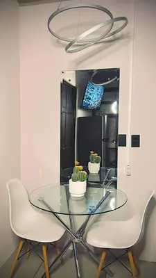 a glass table with two chairs and a mirror at Ken lower apartment in Quepos
