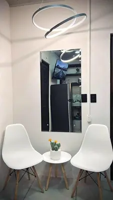 two white chairs and a table in front of a mirror at Ken lower apartment in Quepos