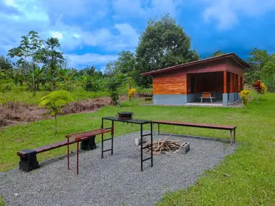 a building with a table and benches in a field at Cabaña Ecos del Río in Jabillos