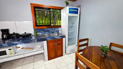 a kitchen with a table and a sink and a counter at Cabaña Ecos del Río in Jabillos