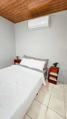 a bedroom with a white bed with a wooden ceiling at Cabaña Ecos del Río in Jabillos
