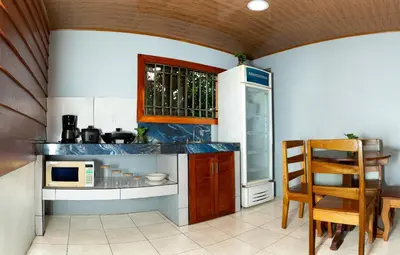 a kitchen with a counter with a microwave and a refrigerator at Cabaña Ecos del Río in Jabillos