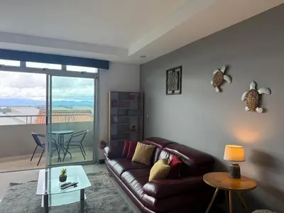 a living room with a leather couch and a table at Escazu Guachipelin Peaceful Getaway, Pool, Wi-Fi & Work Space CR MARIPOSA RENTALS in San Rafael