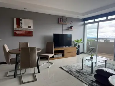 a living room with a tv and a table and chairs at Escazu Guachipelin Peaceful Getaway, Pool, Wi-Fi & Work Space CR MARIPOSA RENTALS in San Rafael
