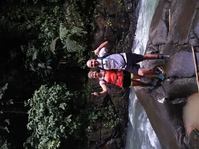 a man is climbing on a waterfall at La Ceiba Ecoadventures Refugio de vida silvestre in Platanillo