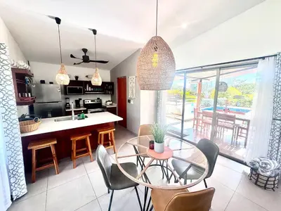 a kitchen and dining room with a glass table and chairs at Casa Bella 3 Bdrm House w Pool in Gated Community in Cuajiniquil