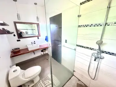 a bathroom with a shower and a toilet and a sink at Casa Bella 3 Bdrm House w Pool in Gated Community in Cuajiniquil