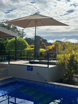 a pool with an umbrella and a table with a pool at Casa Bella 3 Bdrm House w Pool in Gated Community in Cuajiniquil