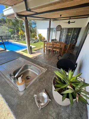 a kitchen with a sink and a table and a dining room at Casa Bella 3 Bdrm House w Pool in Gated Community in Cuajiniquil