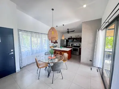 a kitchen and dining room with a glass table and chairs at Casa Bella 3 Bdrm House w Pool in Gated Community in Cuajiniquil