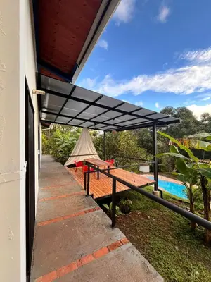a black canopy over a patio with a pool at Casa Rural Los Almendros - Tarcoles in Capulín