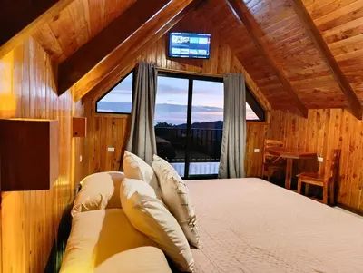 a bedroom with a bed and a window with a television at Cabaña El Trogon in Monteverde Costa Rica