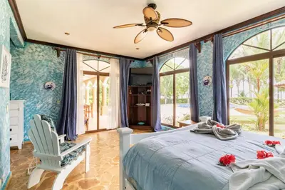 a bedroom with a bed and a ceiling fan at Rancho RachMare in Playa Coyote, a Beach Home! in Nandayure