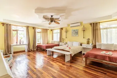 a living room with two beds and a ceiling fan at Rancho RachMare in Playa Coyote, a Beach Home! in Nandayure