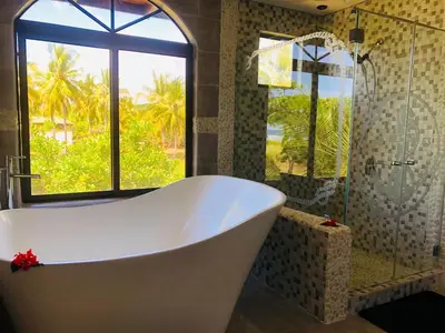 a bath tub in a bathroom with a window at Rancho RachMare in Playa Coyote, a Beach Home! in Nandayure