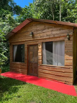 a small cabin with a red carpet and a door at Wildlife Reserve La Ceiba Ecoadventures in Platanillo