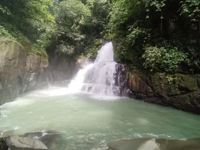 a waterfall in the middle of a pool of water at La Ceiba Biolgical Reserve in Platanillo