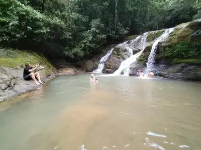 a group of people in the water near a waterfall at La Ceiba Biolgical Reserve in Platanillo