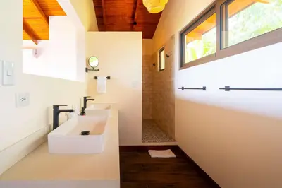 a bathroom with a sink and a window at NEW-Gated-Panoramic sunset ocean view-pool-4 suite in Ojochal