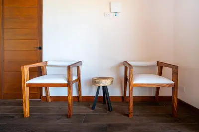 two chairs and a stool next to a door at NEW-Gated-Panoramic sunset ocean view-pool-4 suite in Ojochal