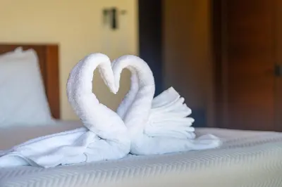 two white swans making a heart on a bed at NEW-Gated-Panoramic sunset ocean view-pool-4 suite in Ojochal