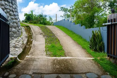 an old dirt road next to a white fence at NEW-Gated-Panoramic sunset ocean view-pool-4 suite in Ojochal