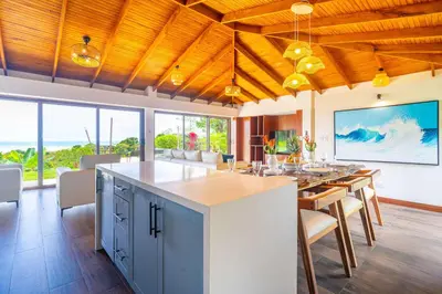 an open kitchen and dining room with a large island at NEW-Gated-Panoramic sunset ocean view-pool-4 suite in Ojochal