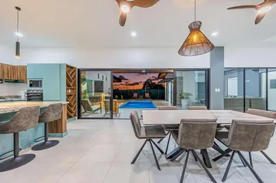 an open kitchen and dining room with a table and chairs at Uvita-New luxury-sleeps 6-private pool-huge patio in Uvita