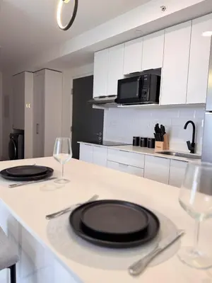 a kitchen with two plates and wine glasses on a counter at Spectacular view and comfort from the 21st floor in San José